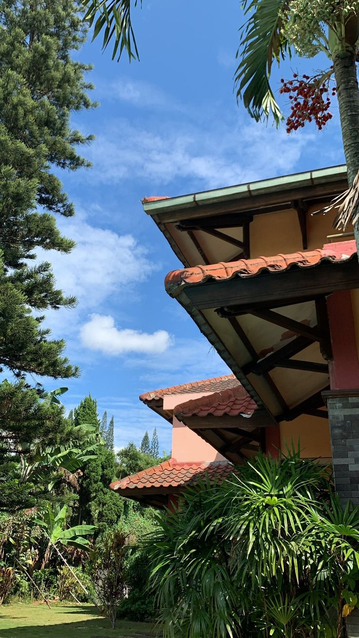 a bench sitting in front of a building with palm trees around it and blue skies above