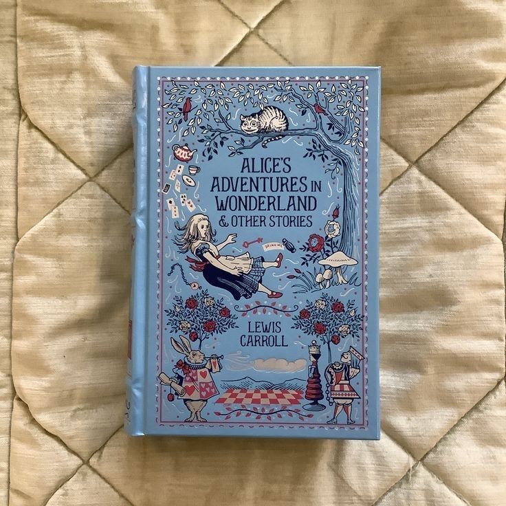 the book alice's adventures in wonderland and other stories sits on a quilted surface