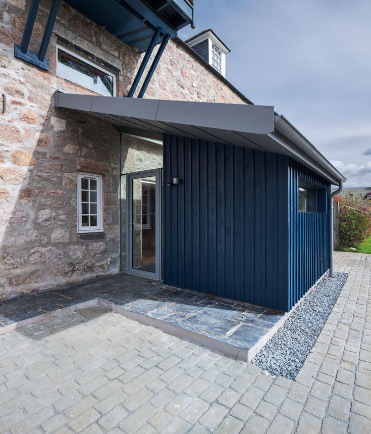 a house with a blue door and brick walkway