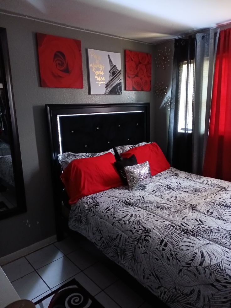 a bedroom with red and black decor on the walls