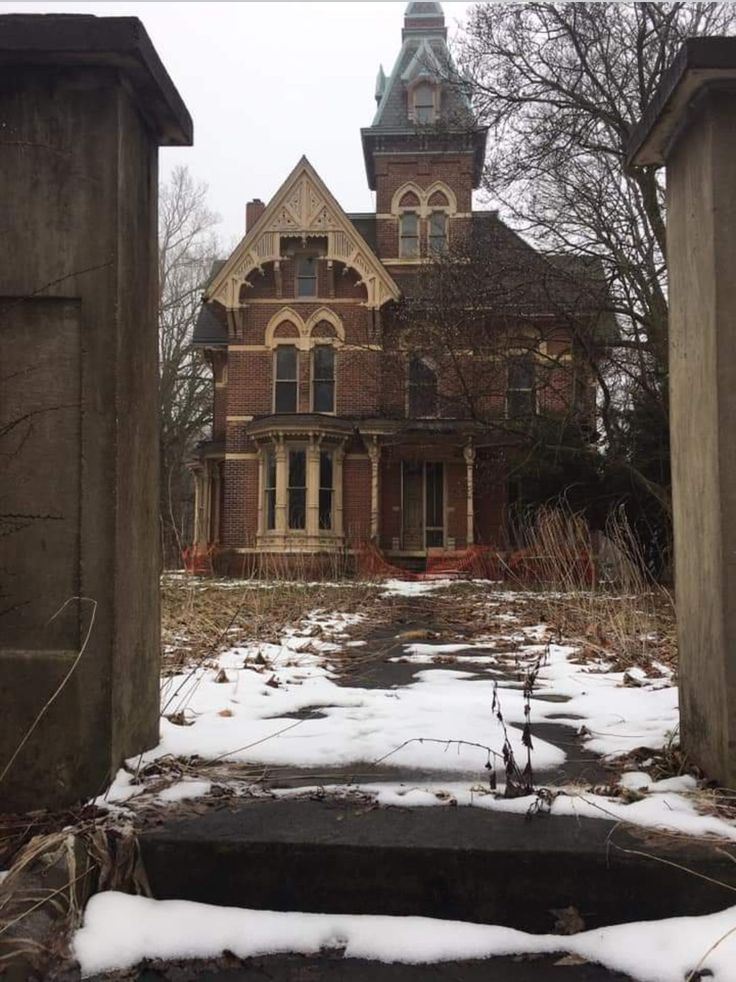 an old house with snow on the ground