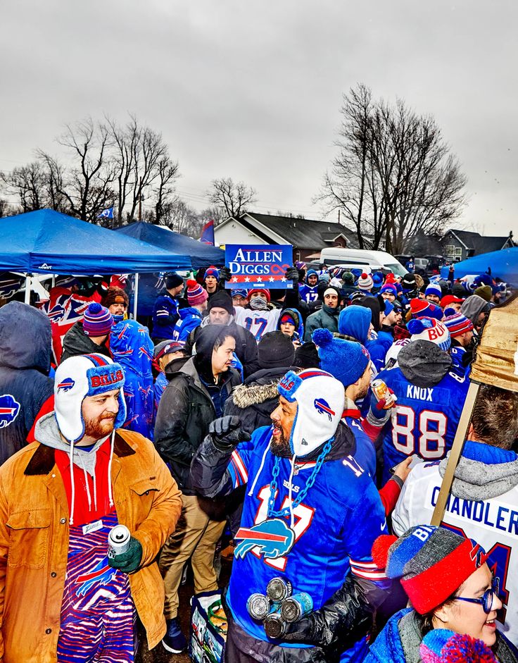 a large group of people standing around each other wearing blue and red hats with numbers on them