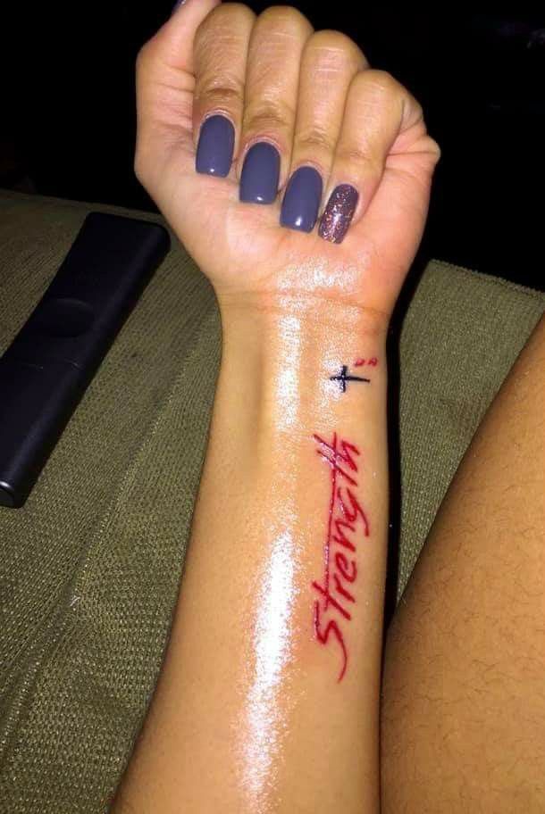 a woman's arm with a tattoo on it and the words faith written in red ink