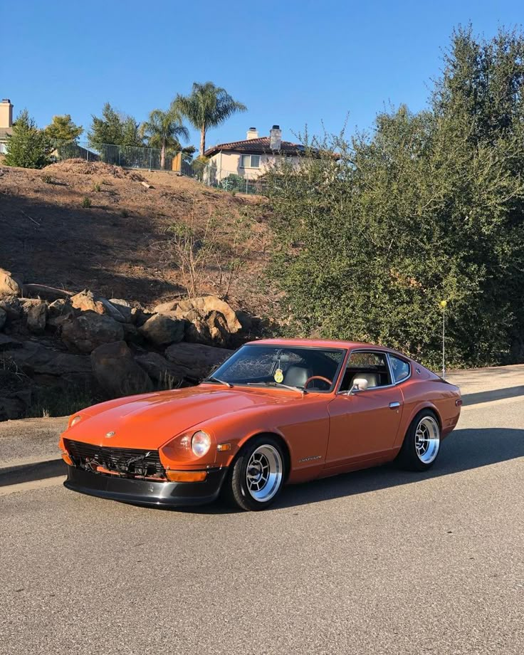 an orange car is parked on the side of the road