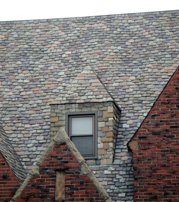 an old brick building with a window in the center and two triangular shaped windows on each side