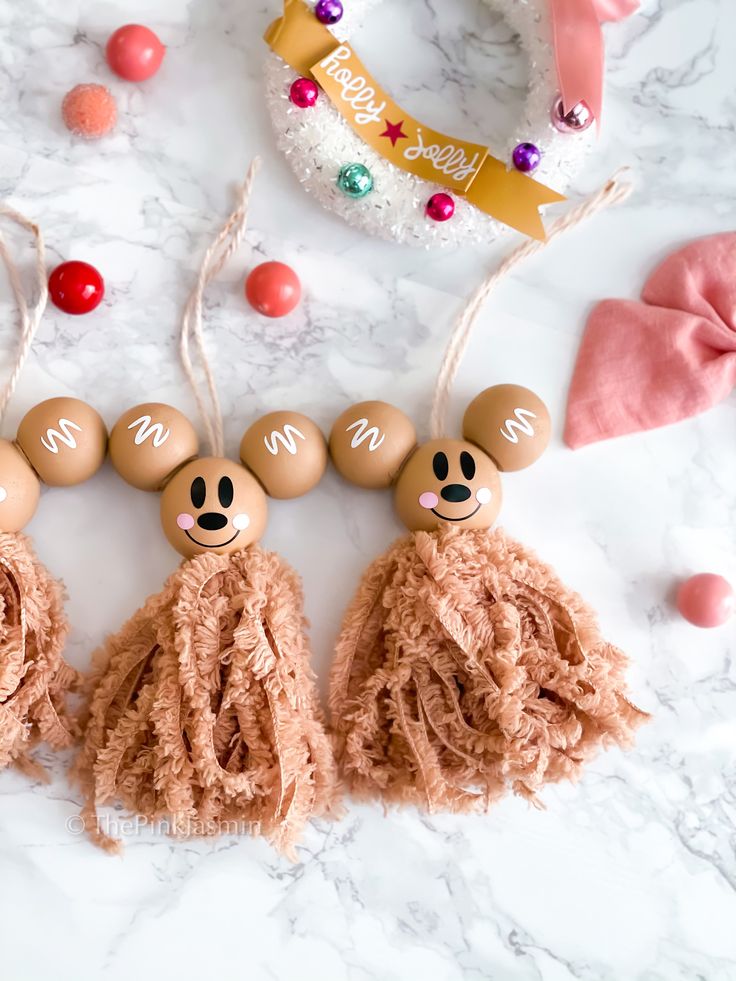 three mickey mouse tassels are hanging on a marble table with candy and decorations around them