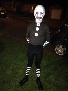 a person in a creepy costume standing on the grass with their face painted to look like a clown