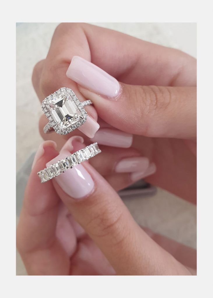 a woman's hands holding two rings and one ring with a diamond on it