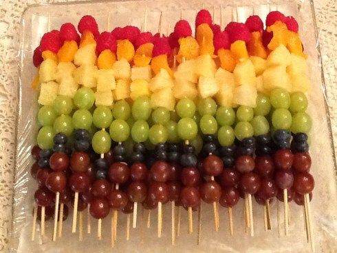 fruit skewers are arranged in the shape of a rainbow