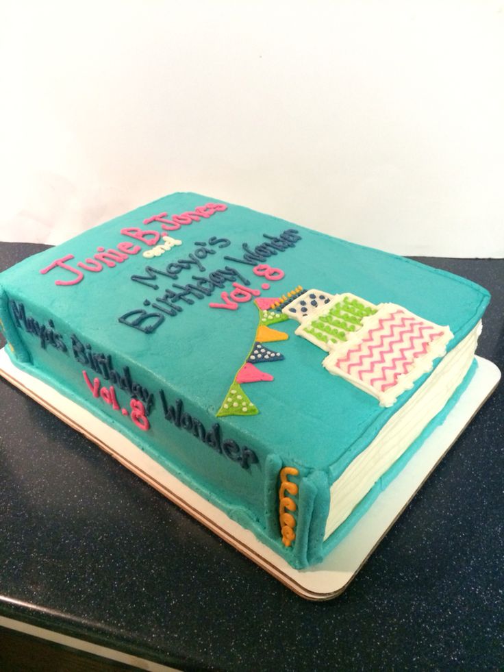 a blue birthday cake with an open book on top