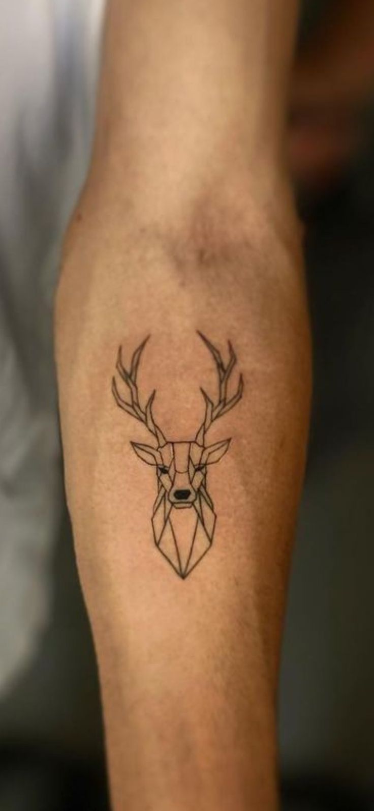 a tattoo on the arm of a man with a deer's head in it