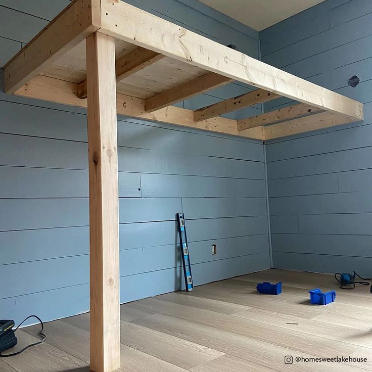 an unfinished room with blue walls and wood floors is being worked on by the same person