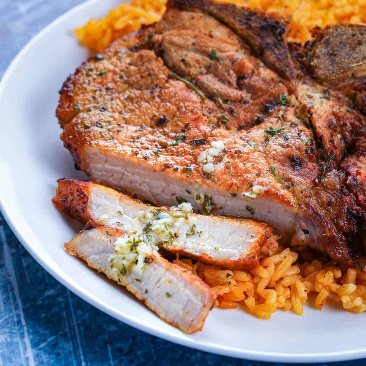 a white plate topped with meat and rice