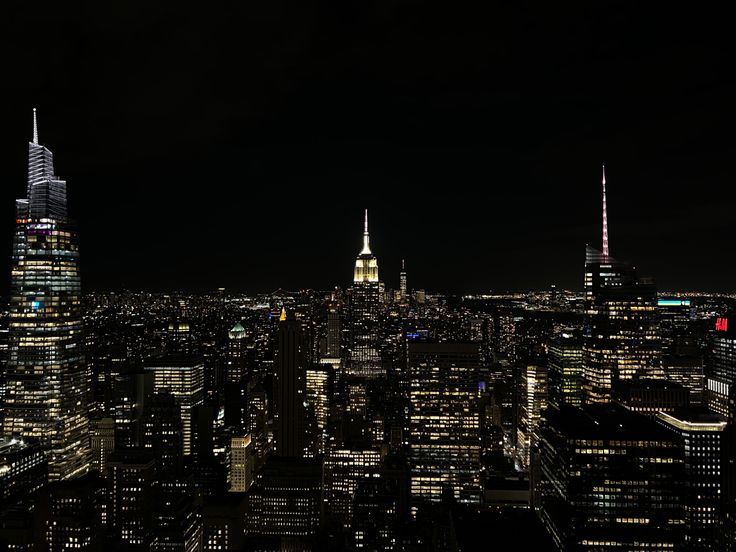 an aerial view of the city at night with skyscrapers lit up in bright colors