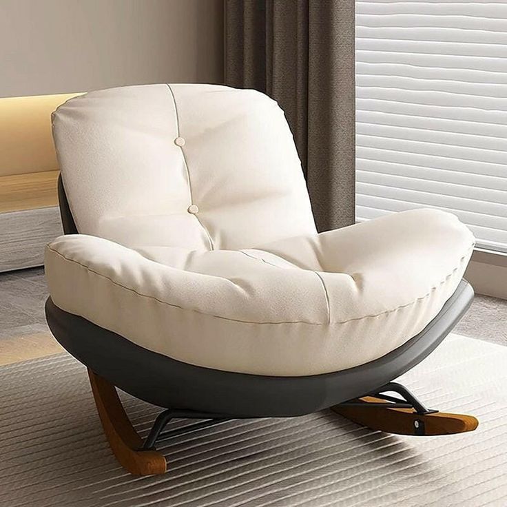 a white chair sitting on top of a rug in a living room next to a window