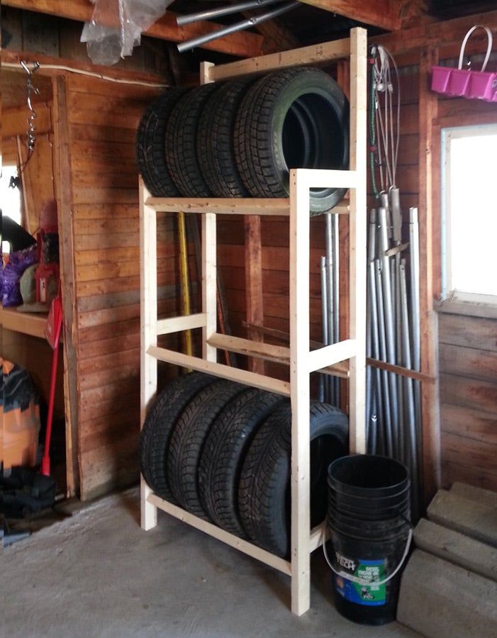 the tire rack is full of tires and other items in this garage with wood paneling