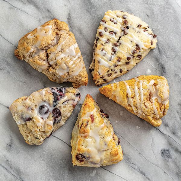 six scones with different toppings on a marble counter top, arranged in a circle