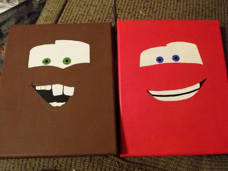 two books with faces painted on them sitting next to each other in front of a couch