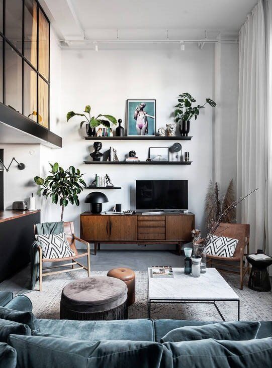 a living room filled with furniture and a flat screen tv on top of a wooden shelf