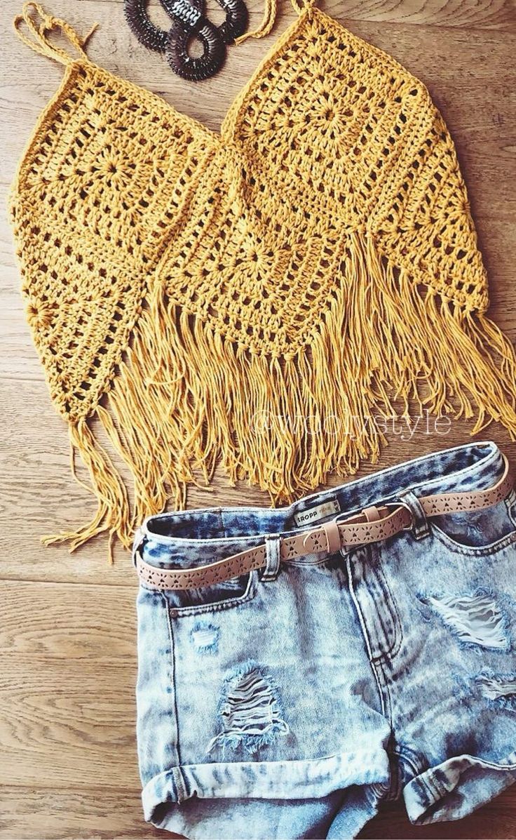 a yellow crochet top and denim shorts with sandals on the floor next to it