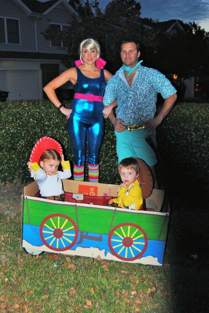 a man and two children are standing in a toy train