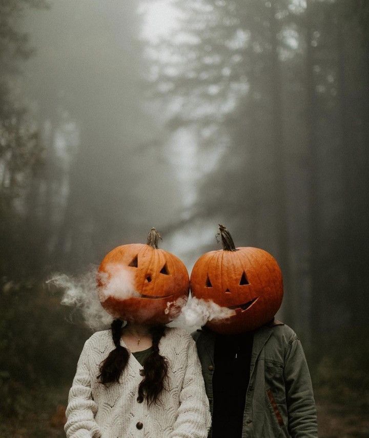 two people with pumpkins on their heads