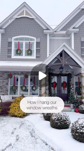 a house with christmas wreaths on the front door and windows decorated for holiday season