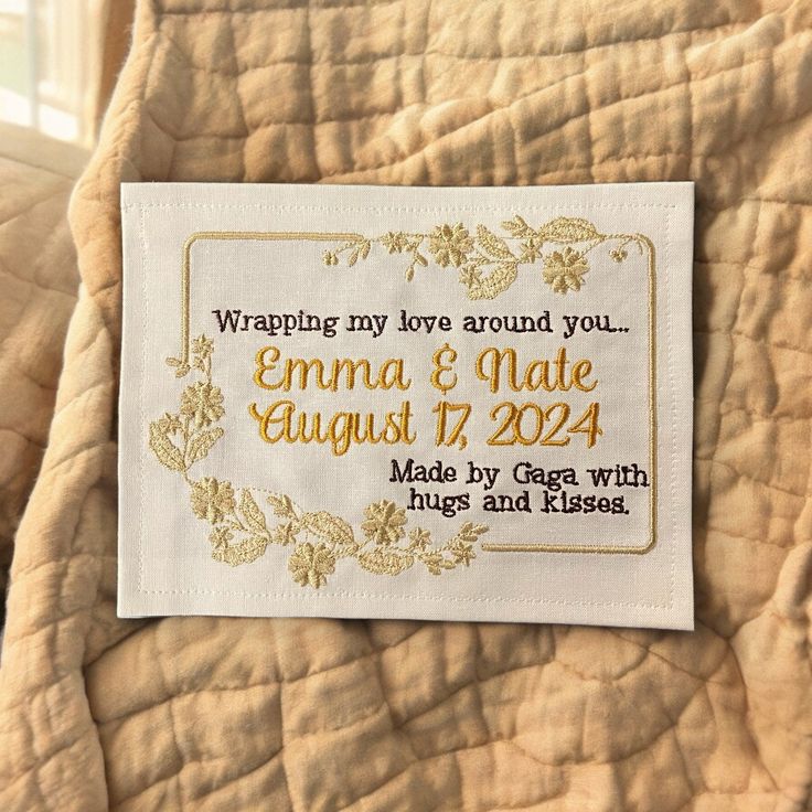 a label on the back of a quilt that says, wrapping my love around you emma & matte august 17, 2014 made by george with hugs and kisses