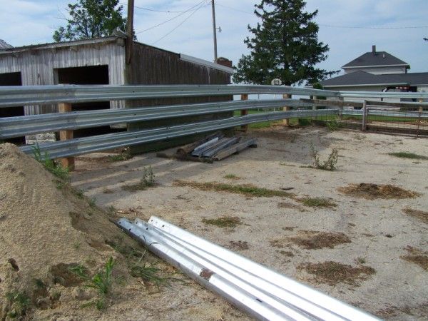 the fence is made of metal and has been placed on top of sand in front of an old building