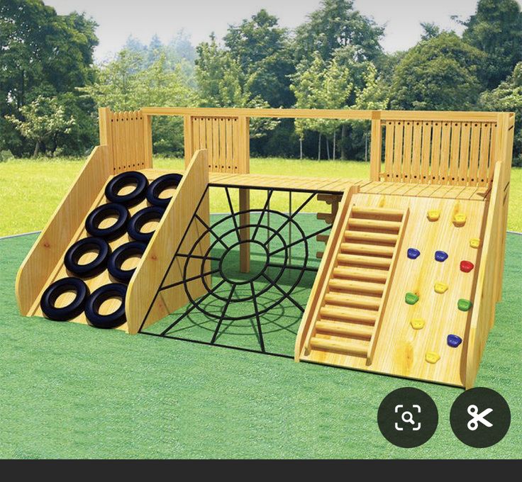 a wooden play set with climbing bars and ladders on the grass in front of trees