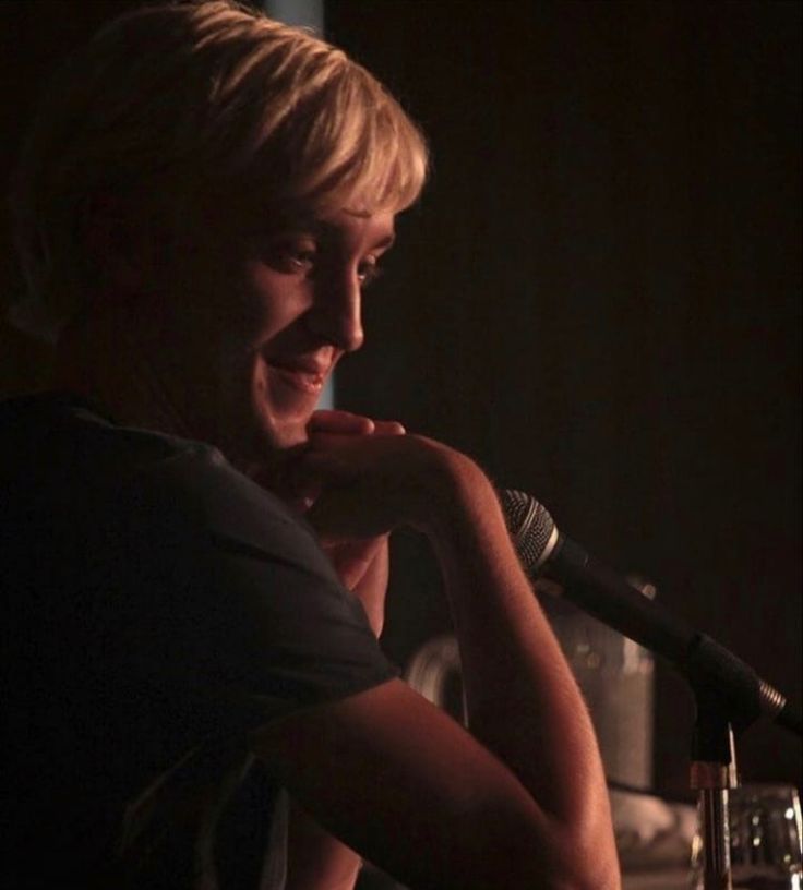 a person sitting at a table with a microphone