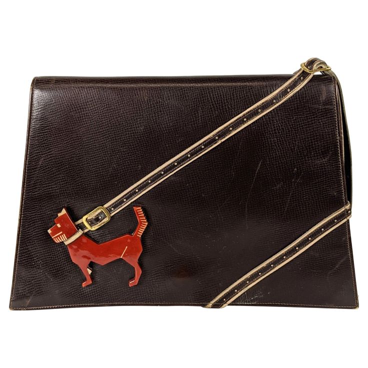 Rare Collectible High Art Deco Bakelite Dog Calf Leather Clutch from the 1930's by Virginia Bags. A carved and patinaed futurist bakelite dog is anchored by a perforated leather leash which becomes the handle at the top of the bag. 1930's. 9" x 6" x 1.5". Handle 4.5". Art Deco Bag, New York Fits, Devil Wears Prada, Gorgeous Clothes, High Art, Estilo Art Deco, Perforated Leather, Purse Accessories, Vintage Handbags