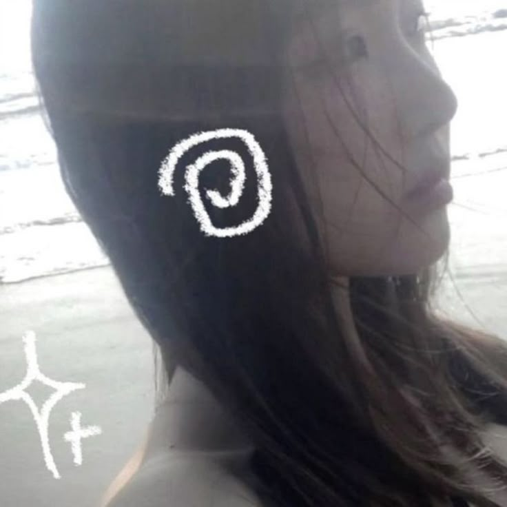 a girl with long hair has an ear pin in the shape of a letter p