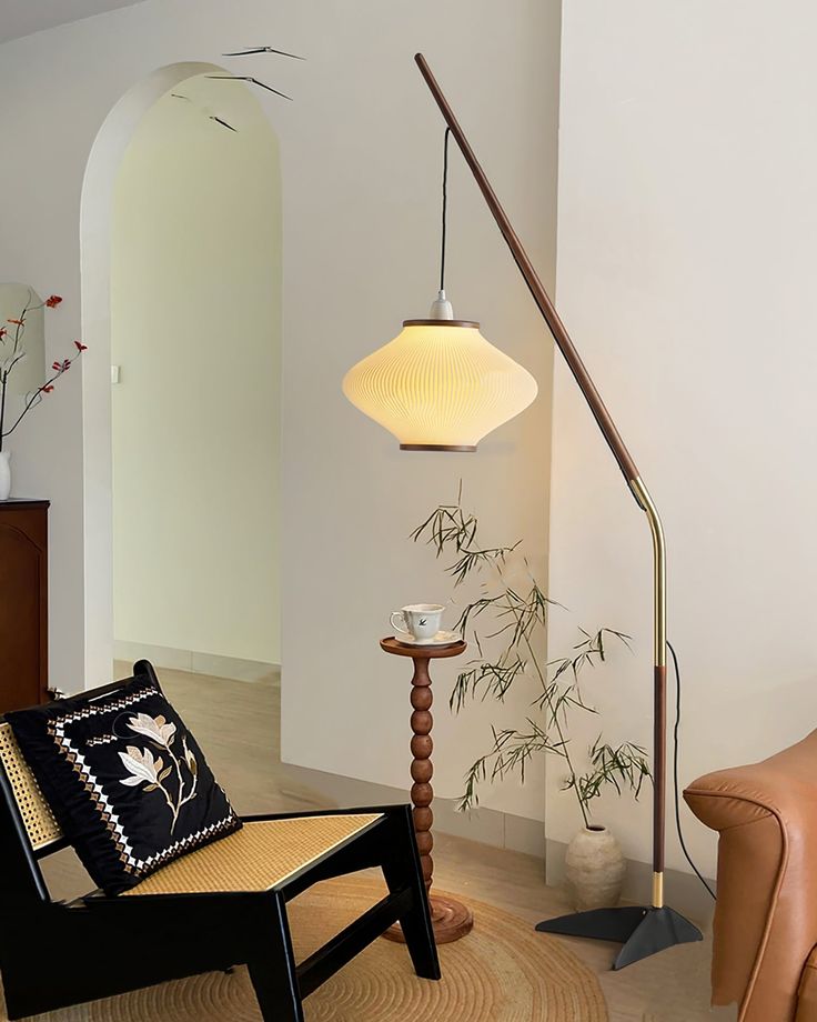 a living room filled with furniture and a lamp on top of a wooden table next to a chair