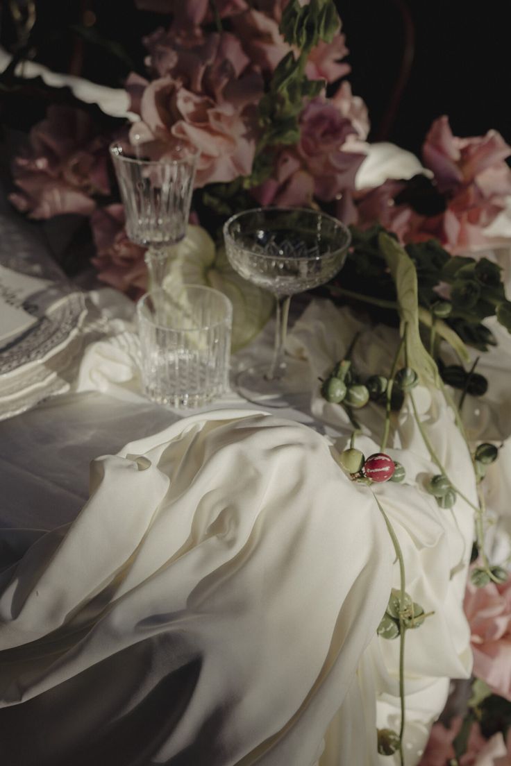 the table is covered with flowers and glassware