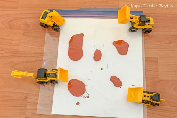 four construction vehicles on top of a piece of paper