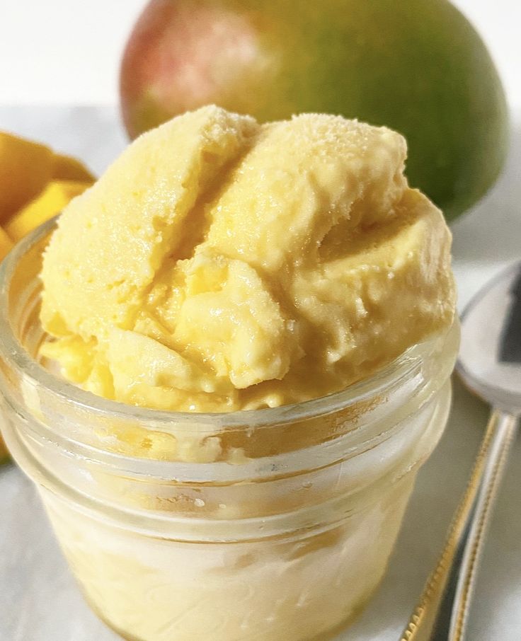 a jar filled with ice cream next to some fruit