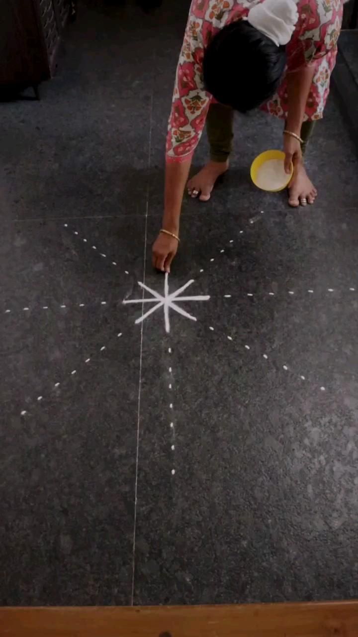 a woman bending over to pick up a frisbee on the floor with stars drawn on it