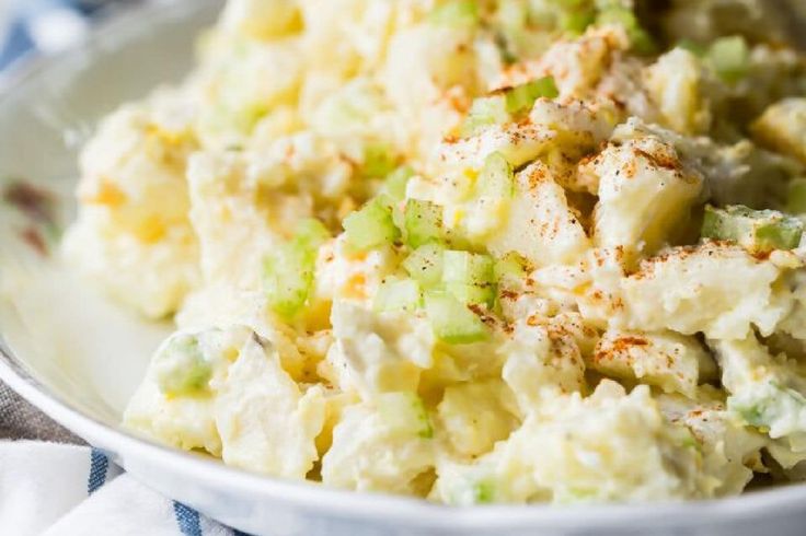 a white bowl filled with mashed potatoes and celery