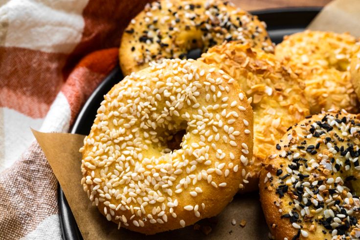 bagels with sesame seeds and sprinkles are on a plate, ready to be eaten