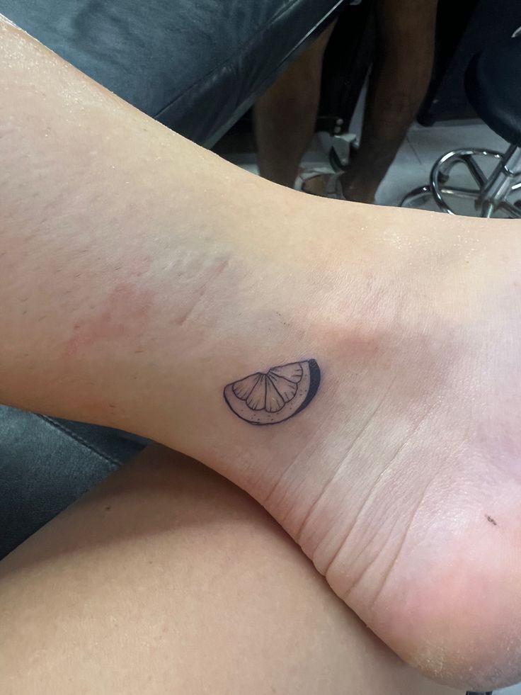 a person's foot with a small tattoo on the side of their left leg