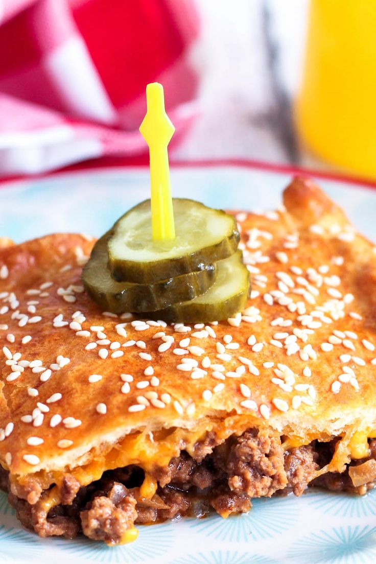 a piece of food on a plate with a pickle sticking out of the top