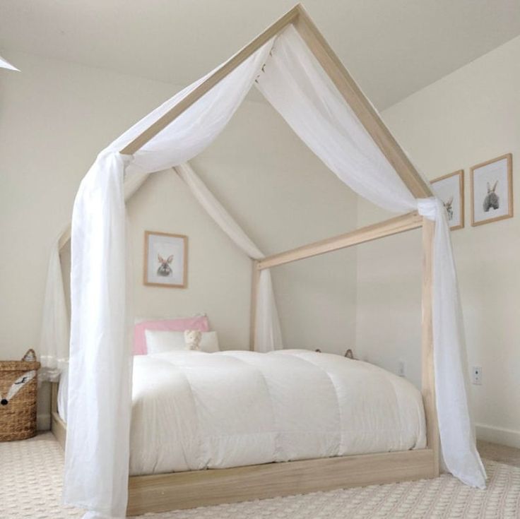 a white bed sitting in a bedroom on top of a floor next to a window