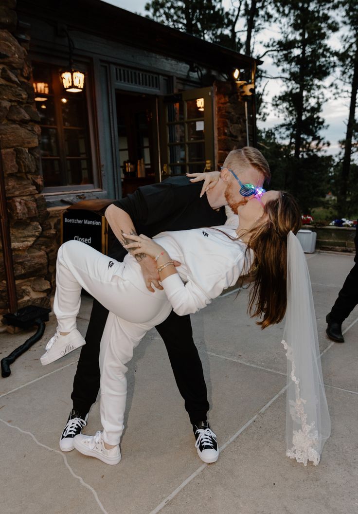 a bride and groom kissing on the street