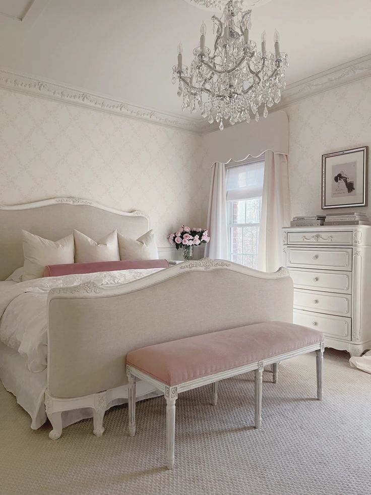 a bedroom with white furniture and a chandelier hanging from it's ceiling