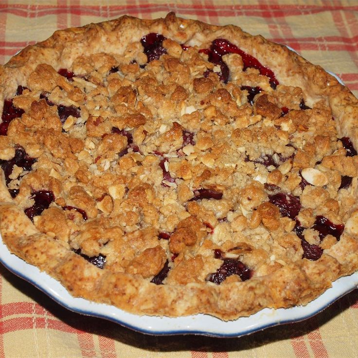 a pie sitting on top of a table covered in crumbs and toppings