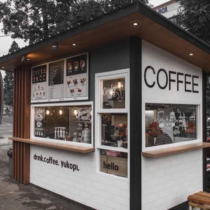 a small coffee shop sitting on the side of a road