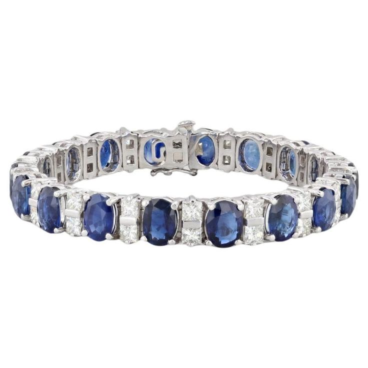 This stunning custom bracelet is set with deep blue oval sapphires accented by VS2 princess diamonds, creating a lovely white and blue contrast along a polished platinum chain. This statement piece displays the highest craftsmanship and comes with a GIA certificate for the sapphires as well as with an inner black velveteen box and outer white box. Gemstone Information: - Natural Sapphires - Total Carats - 29ctw Cut - Oval Brilliant Color - Blue Treatment - Heated GIA#: 1226436814 Geographic Orig Blue Sapphire Bracelet, Platinum Chain, Ceylon Blue Sapphire, Gia Certificate, Custom Bracelet, Sapphire Bracelet, Princess Diamond, White Box, Tennis Bracelet Diamond