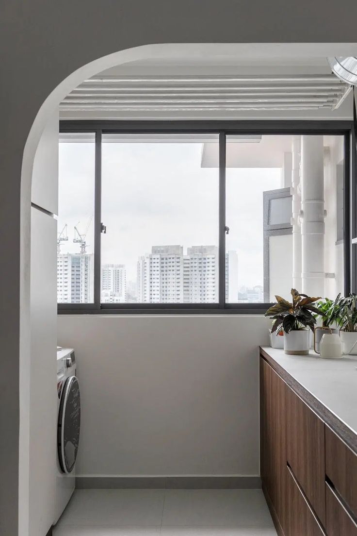 a bathroom with a washer and dryer next to a window overlooking the city