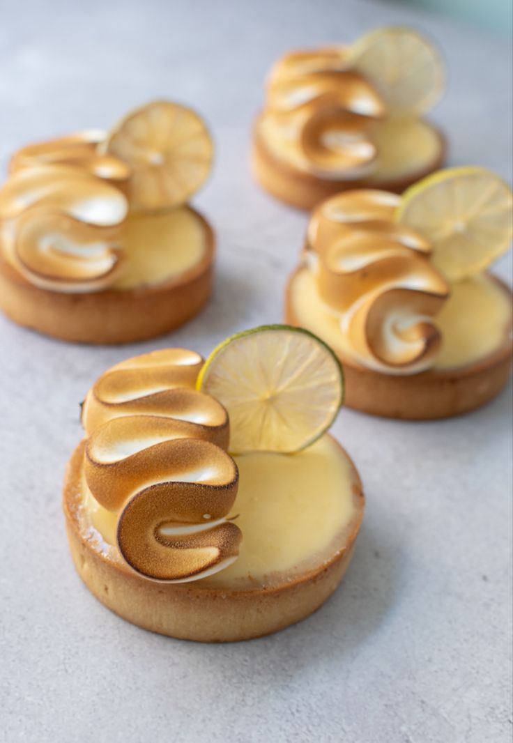 lemon custard tarts with icing on top and sliced lemons in the middle